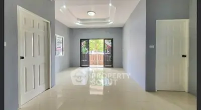 Spacious modern living room with glossy tile flooring and large windows for natural light.