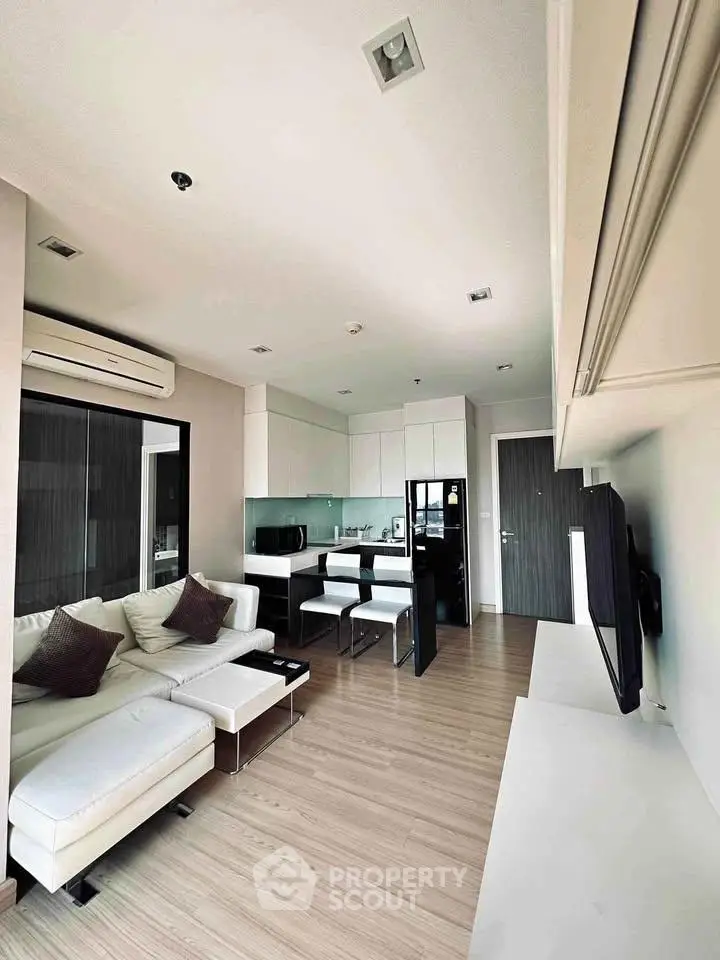 Modern living room with open kitchen, sleek furniture, and stylish decor in a contemporary apartment.