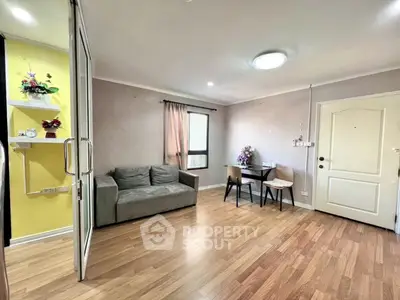 Charming living room with cozy sofa and dining area, featuring elegant wooden flooring and bright decor.