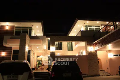 Stunning modern two-story house with elegant lighting and spacious driveway at night.