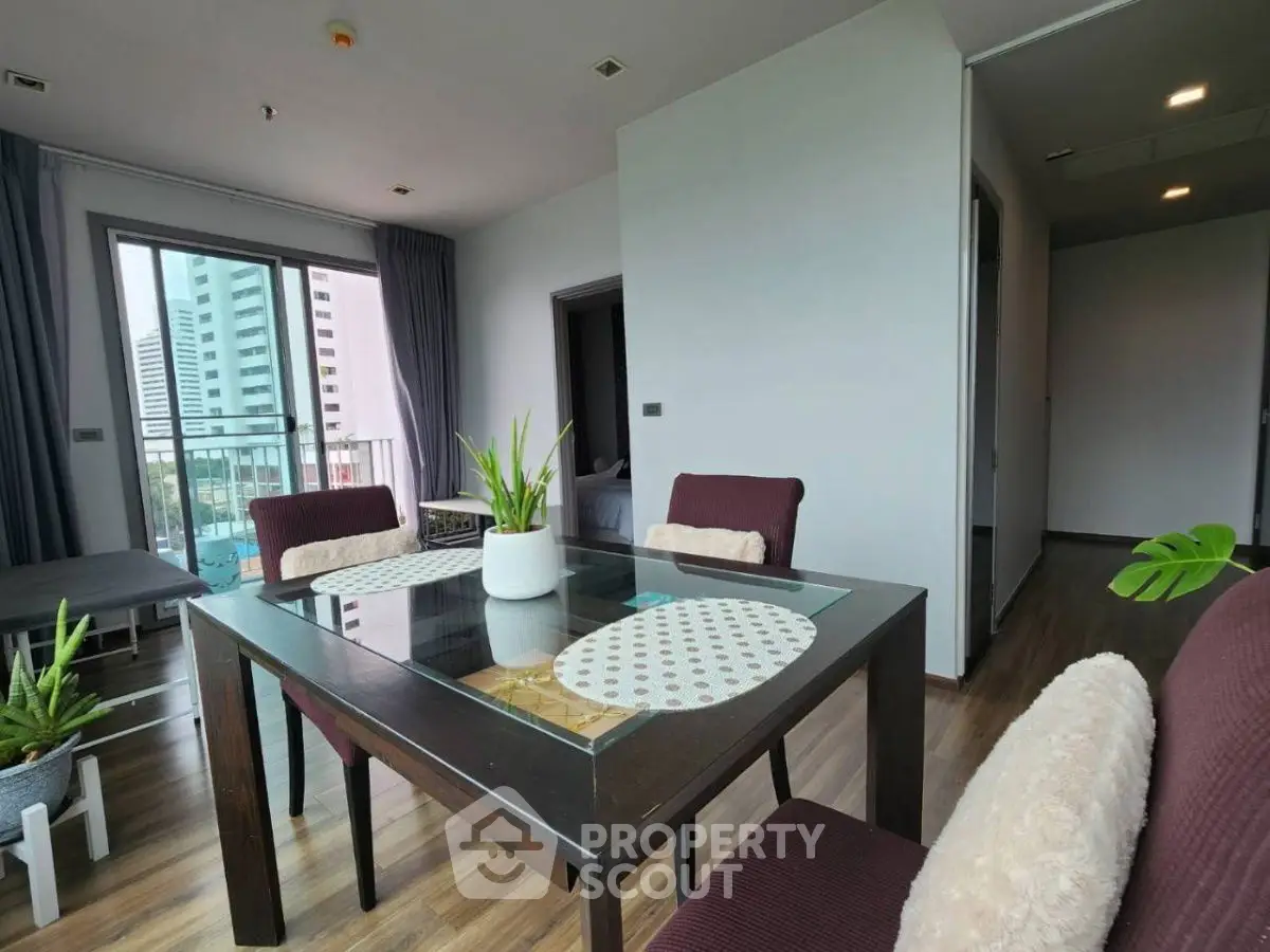 Modern dining area with glass table and city view in stylish apartment