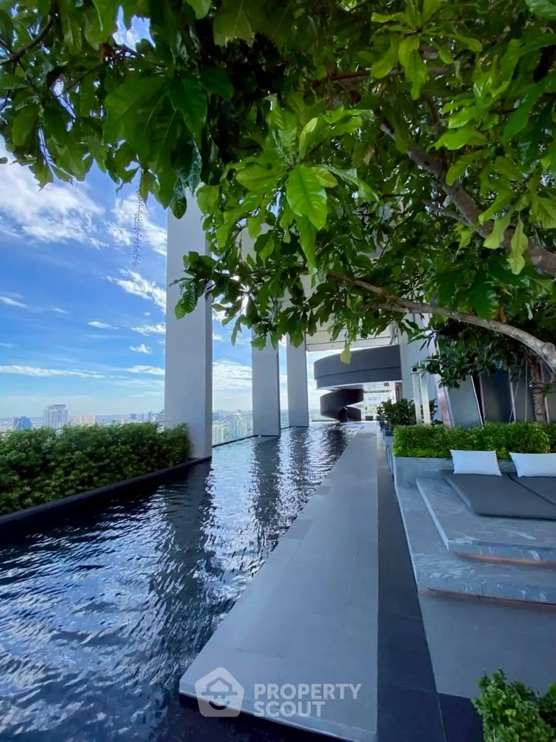 Luxurious rooftop pool with stunning city views and lush greenery, perfect for relaxation and leisure.