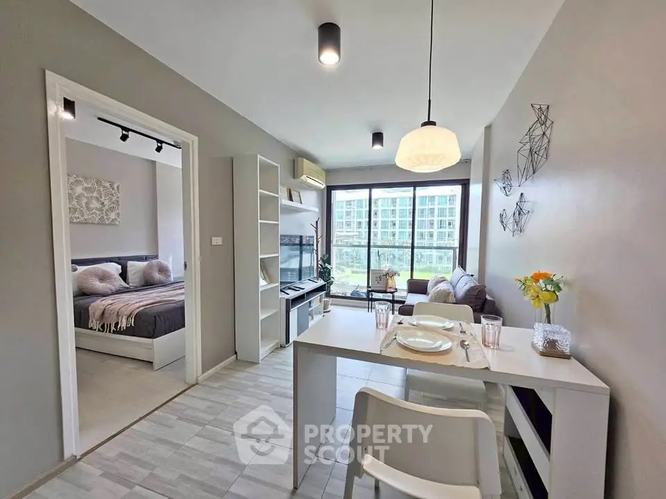 Modern open-plan living room with dining area and large windows in a stylish apartment.