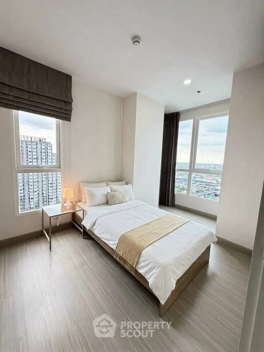 Bright and modern bedroom with city view in high-rise apartment