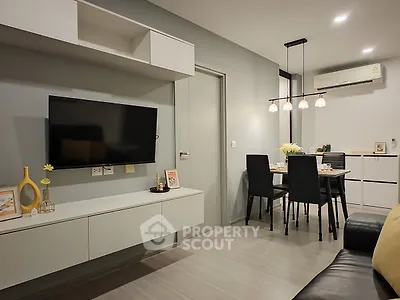 Modern living room with sleek furniture and dining area, featuring a wall-mounted TV and stylish lighting.