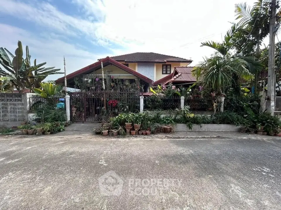 Charming suburban house with lush garden and red-tiled roof, perfect for family living.