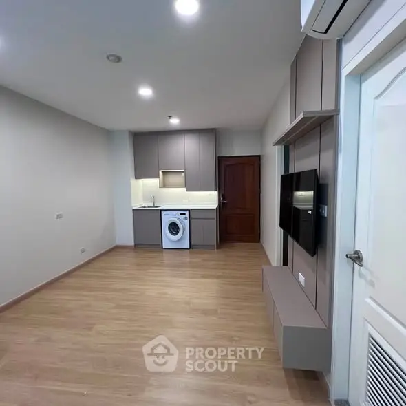 Modern compact living space with sleek kitchen and built-in appliances, ideal for urban living.