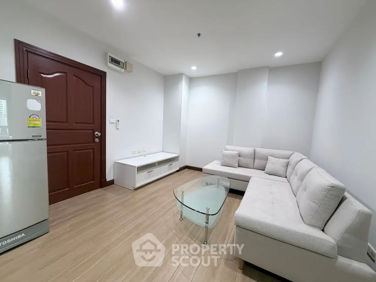 Modern living room with sleek furniture and wooden flooring in a cozy apartment.