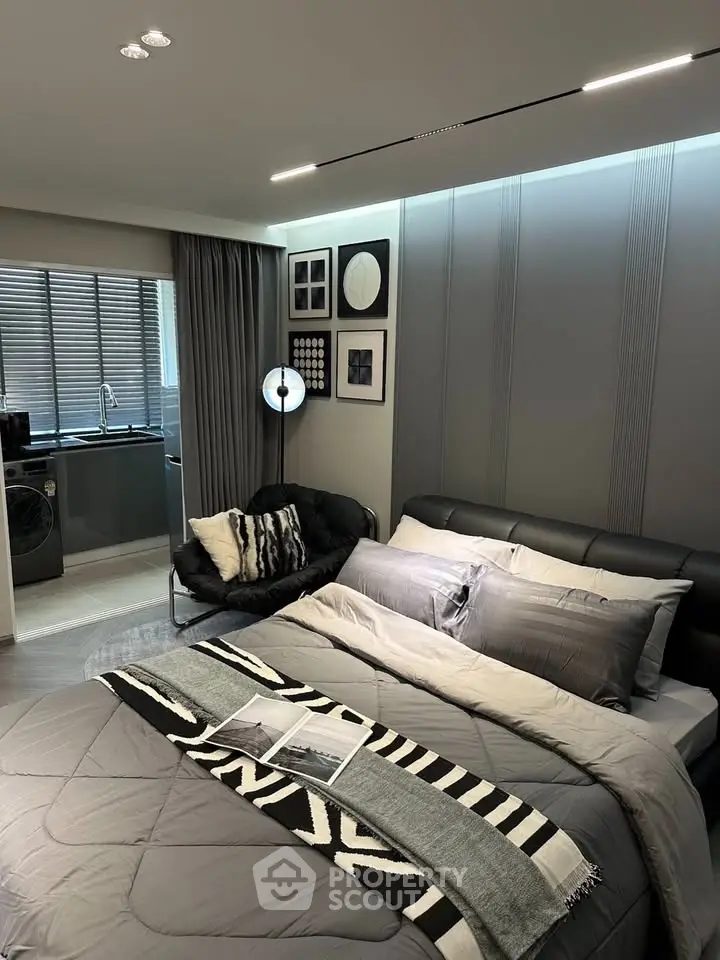 Modern bedroom with stylish decor and open kitchen layout in a cozy apartment.