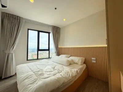 Modern bedroom with large window offering stunning city views, featuring cozy bedding and elegant wooden accents.