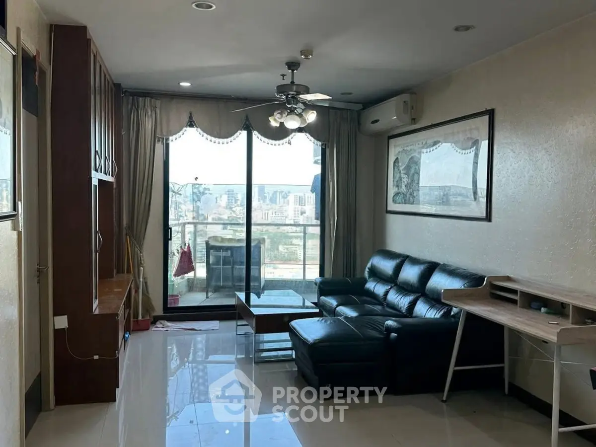 Spacious living room with city view, modern furniture, and natural light.
