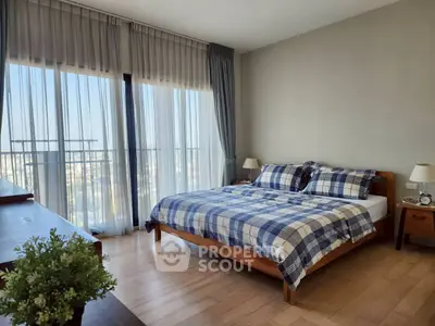 Spacious bedroom with large windows and stylish decor, offering a serene and comfortable living space.