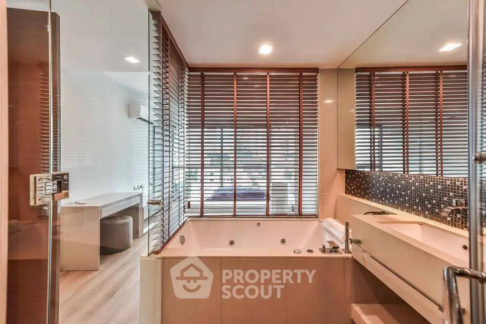 Luxurious bathroom with modern design and spacious bathtub, featuring elegant wooden blinds.
