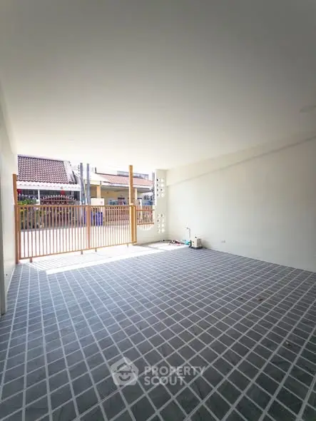 Spacious covered parking area with tiled flooring and natural light