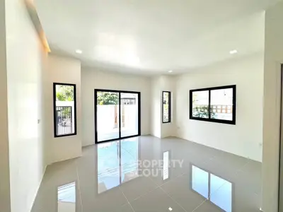 Spacious modern living room with large windows and glossy tiled floors
