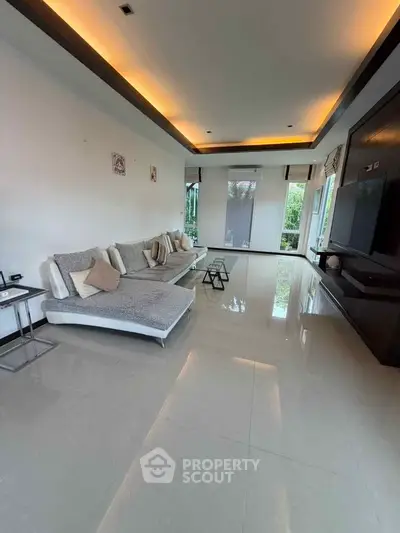 Spacious modern living room with sleek design and large windows offering natural light.