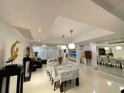 Luxurious open-plan living and dining area with modern decor and elegant lighting.