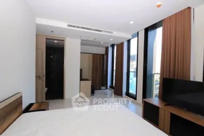 Modern bedroom with large windows and stylish furniture in a high-rise apartment.