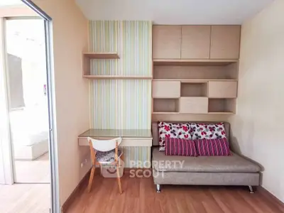 Charming study nook with built-in shelves and cozy seating in modern apartment.