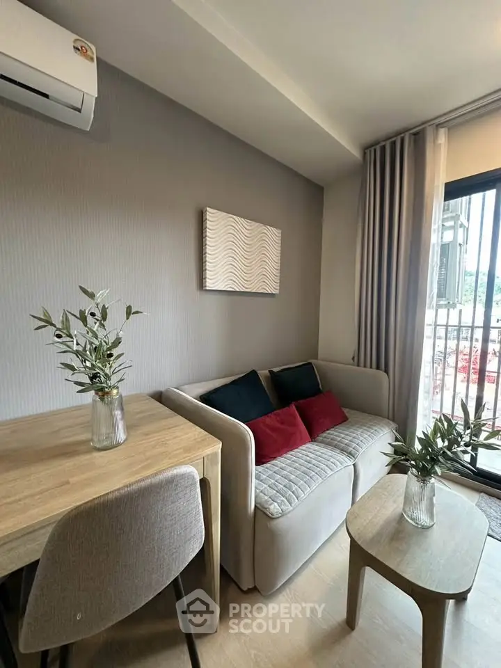 Modern living room with cozy sofa, stylish decor, and balcony view