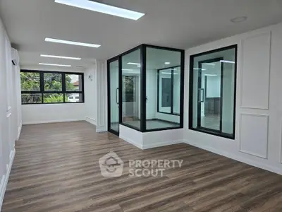 Spacious modern living room with large windows and elegant wood flooring