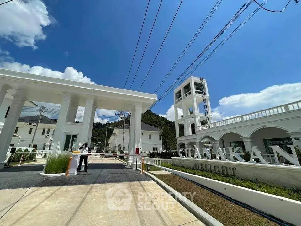 Luxurious gated community entrance with elegant architecture and scenic mountain backdrop.