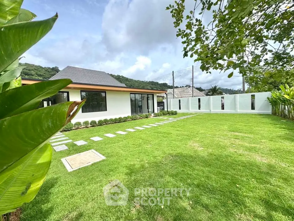 Spacious modern home with lush green lawn and scenic surroundings