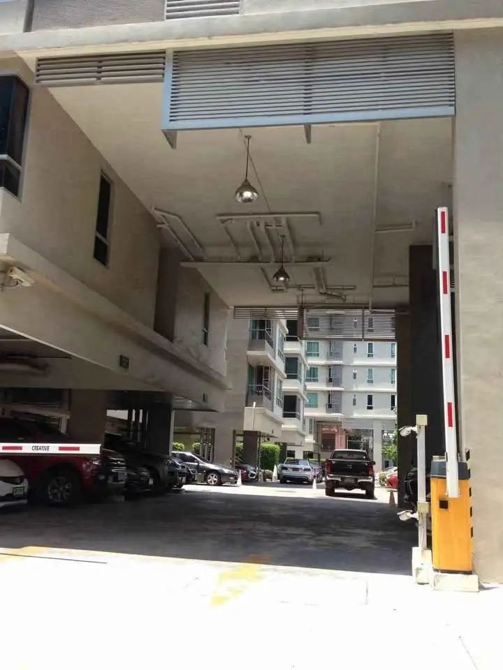 Modern apartment building entrance with parking area and security gate