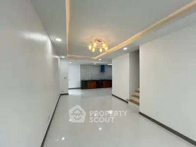 Spacious modern living room with sleek lighting and open kitchen layout