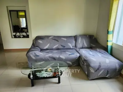 Cozy living room with modern sofa and glass coffee table, perfect for relaxation.