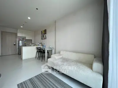 Modern living room with open kitchen layout and cozy sofa in bright apartment