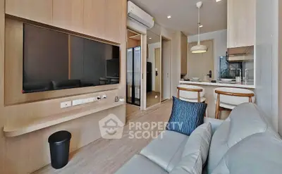 Modern living room with open kitchen, sleek wooden finishes, and stylish furniture in a cozy apartment.