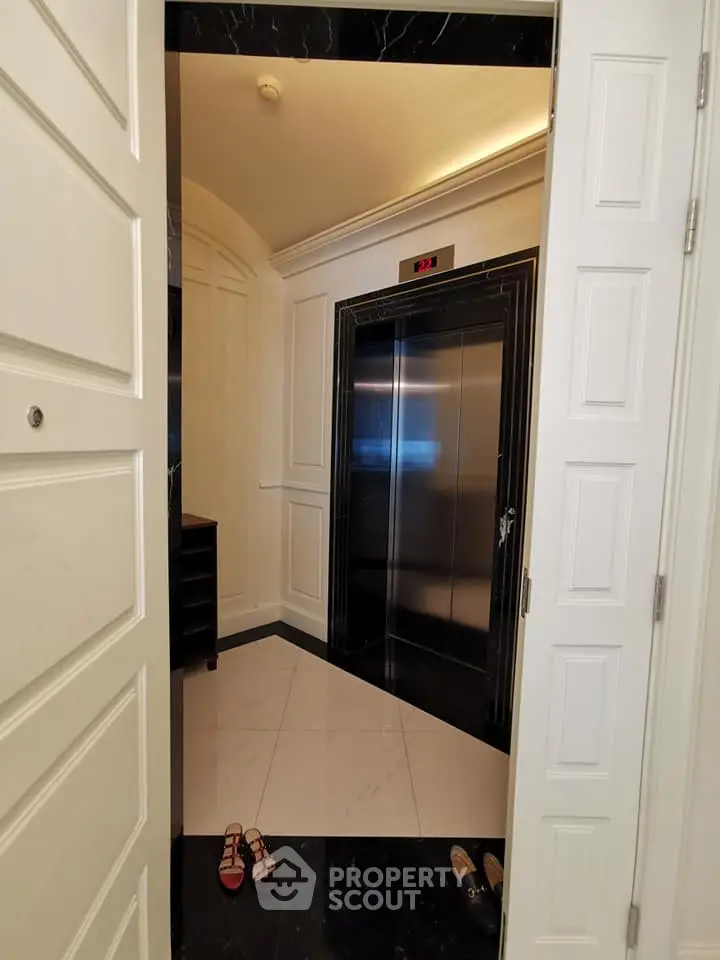 Luxurious elevator entrance with elegant marble flooring and stylish paneling