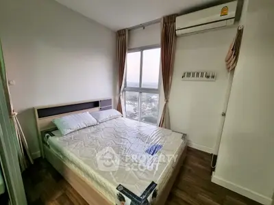 Cozy bedroom with large window offering stunning city view, featuring a comfortable bed and air conditioning.