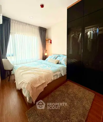 Cozy bedroom with large window and modern wardrobe in stylish apartment.