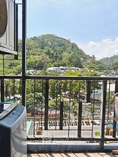 Scenic balcony view with lush hills and urban landscape, perfect for relaxation and city living.