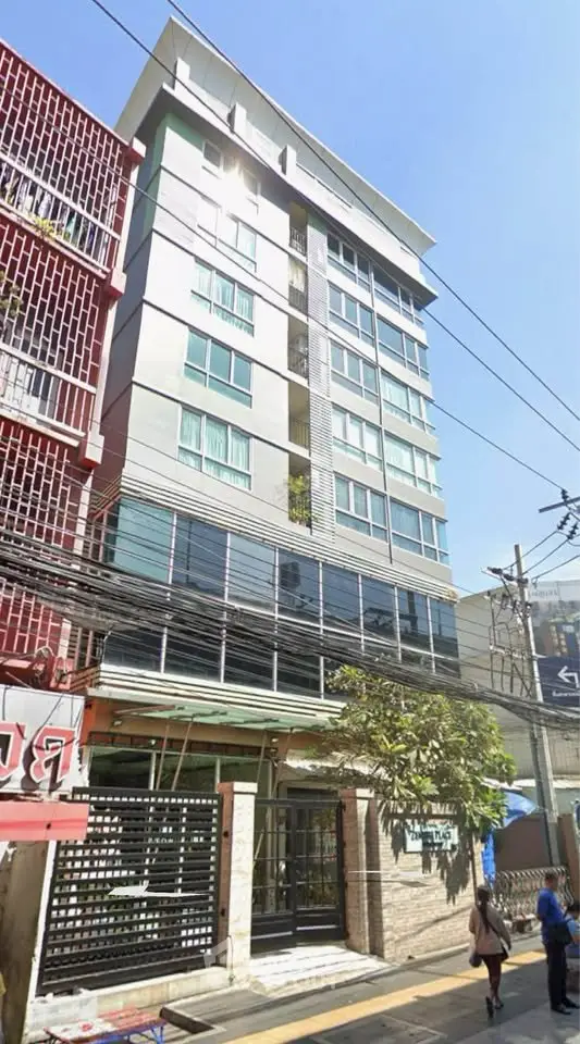 Modern multi-story building with sleek facade and large windows in urban setting.