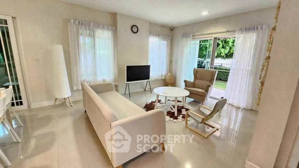Spacious living room with modern furniture and large windows offering natural light.