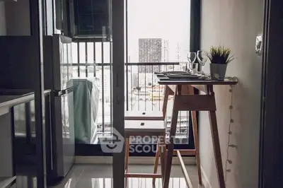 Modern apartment balcony with dining setup and city view.