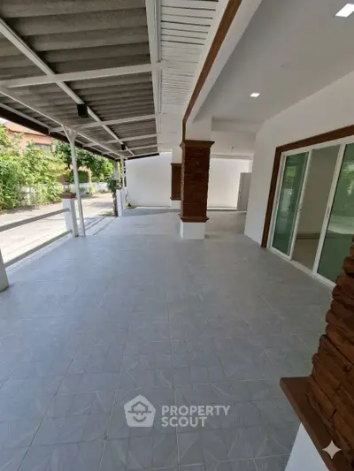 Spacious covered patio with modern tile flooring and sliding glass doors