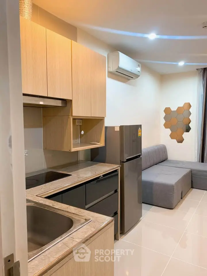 Modern apartment interior with sleek kitchen and cozy living area featuring stylish furniture.
