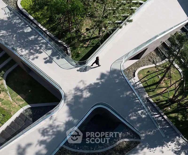 Stunning aerial view of modern architectural building with lush greenery and unique design.