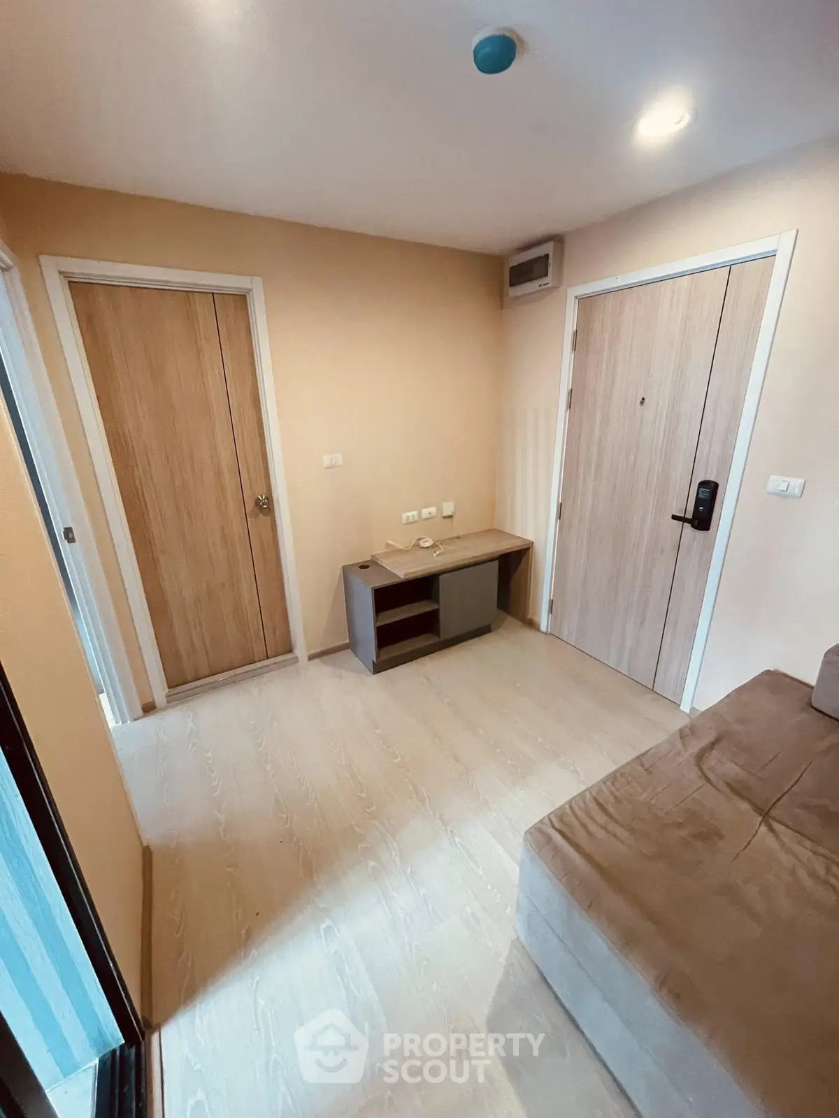 Cozy apartment entrance with modern wooden doors and a compact storage unit.