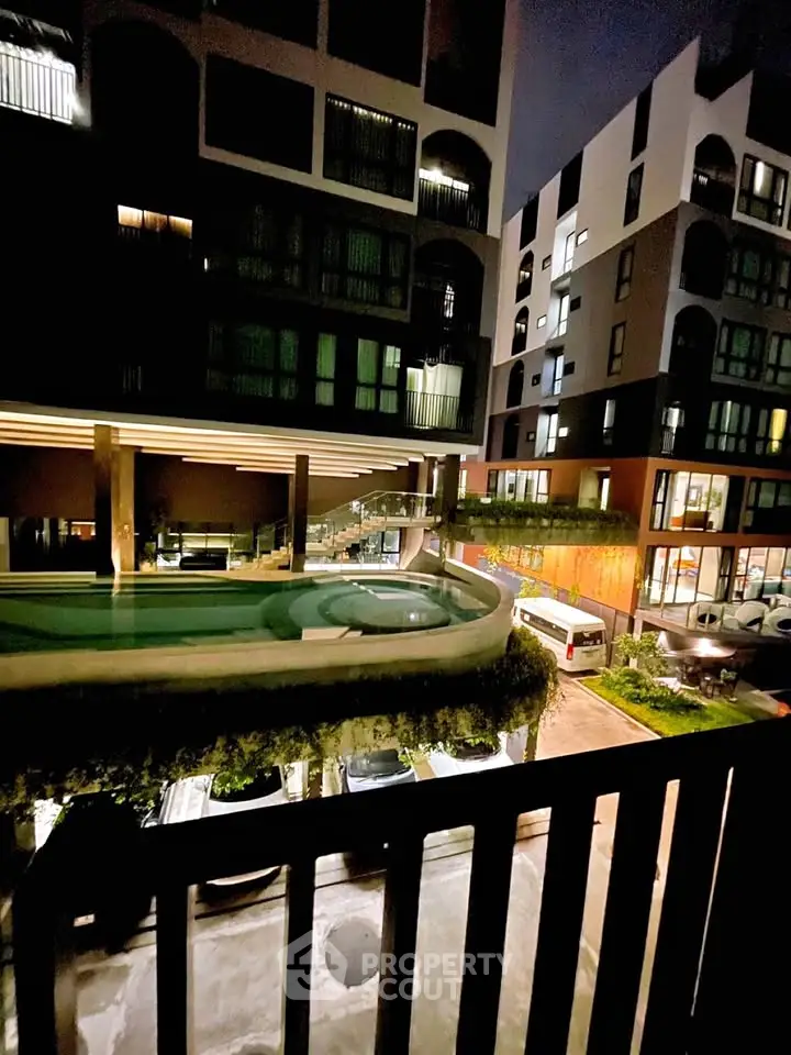 Modern apartment complex with pool and night lighting, showcasing urban living.