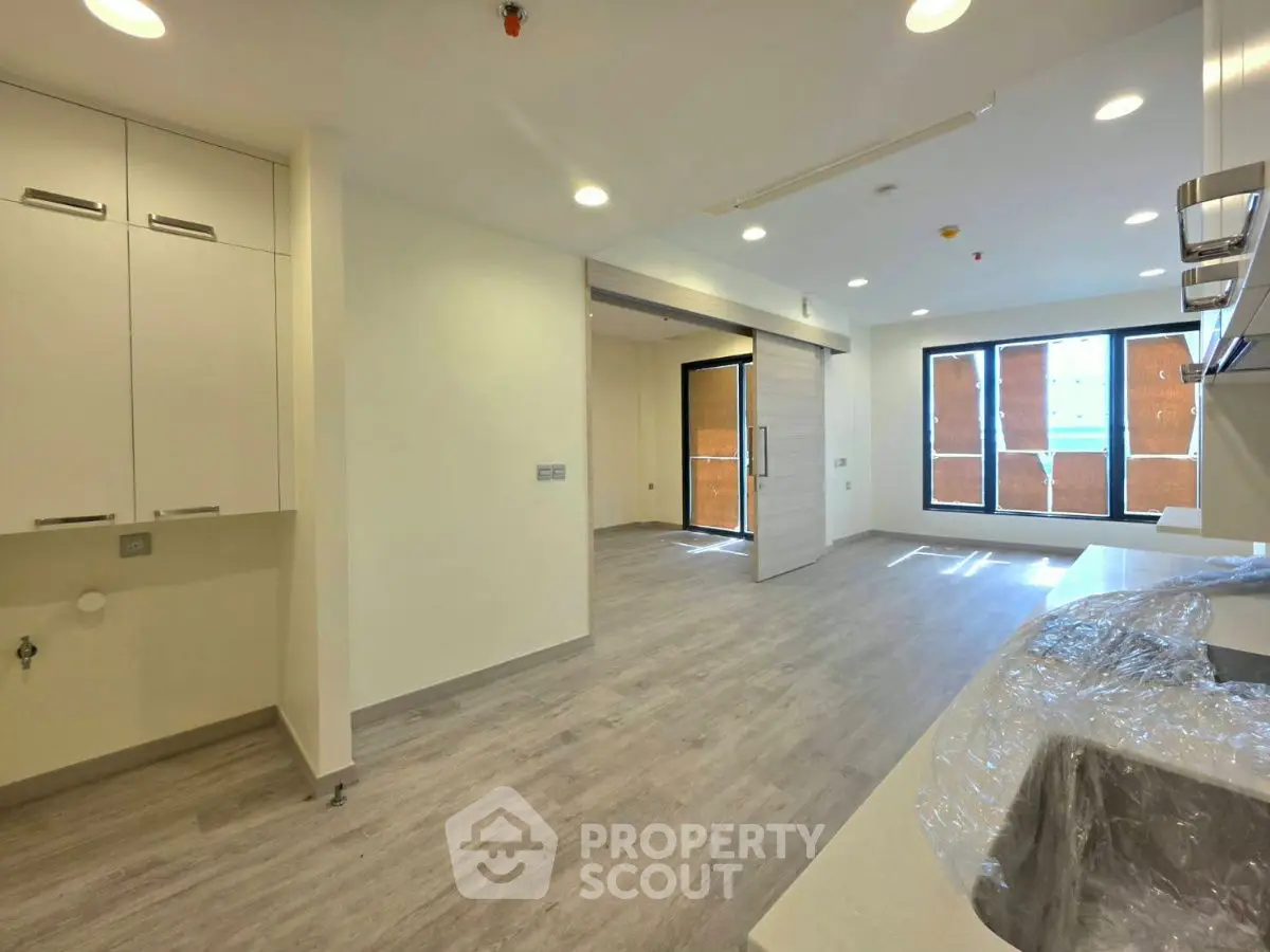 Modern open-plan kitchen and living area with sleek design and ample natural light.