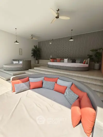 Luxurious modern living room with stylish seating and ceiling fans, perfect for relaxation and entertainment.