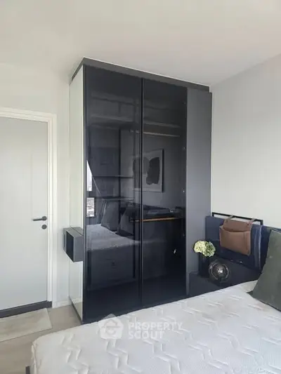 Modern bedroom with sleek black wardrobe and stylish decor