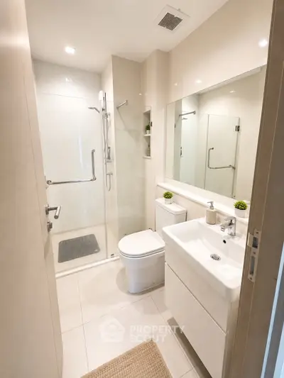 Modern bathroom with sleek fixtures and spacious shower in contemporary apartment.