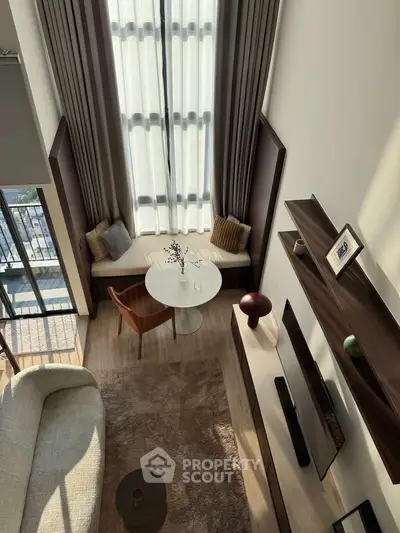 Luxurious modern living room with high ceilings, large windows, and elegant decor, offering a bright and airy ambiance.