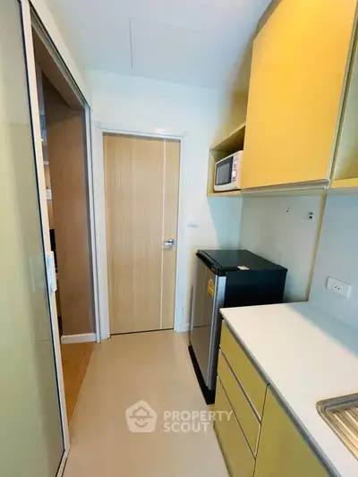 Modern kitchen with sleek cabinetry and compact appliances in a stylish apartment.